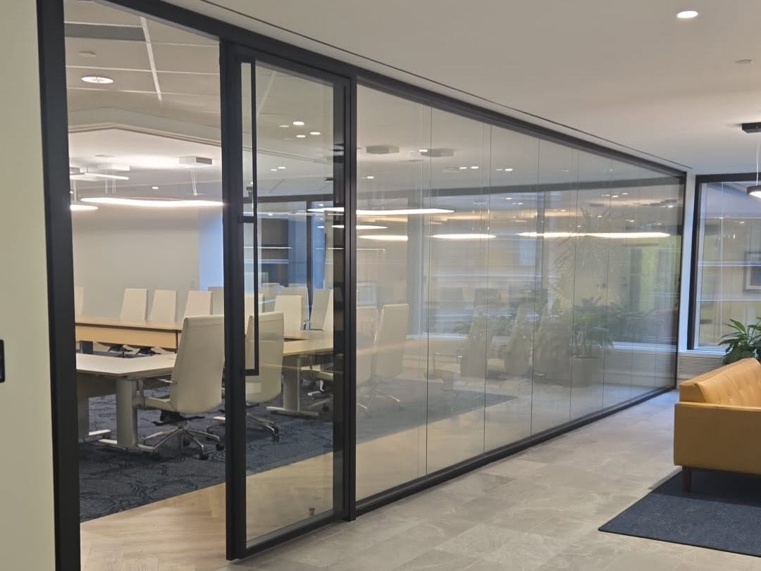 Conference room behind a long black-framed glass wall