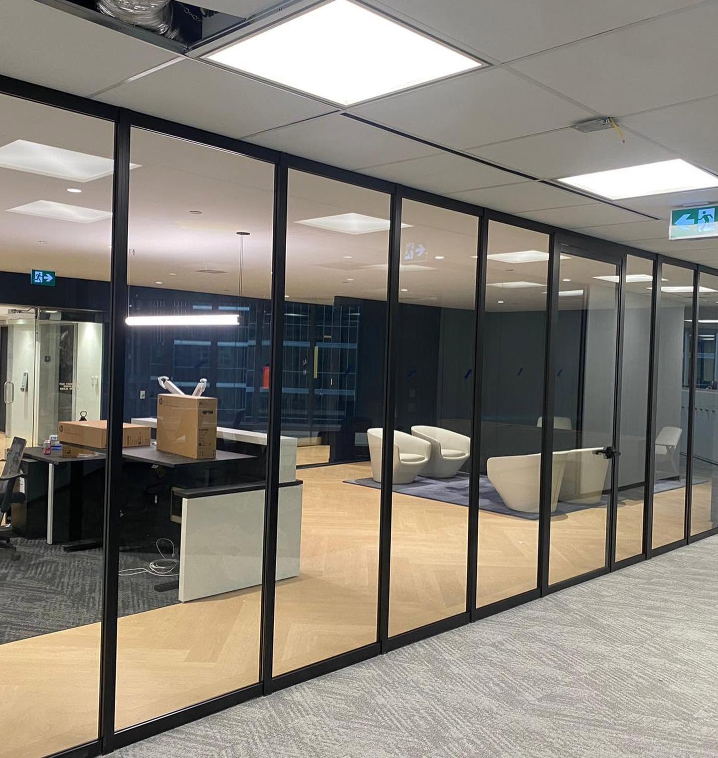 Large black-framed glass office front with lounge seating